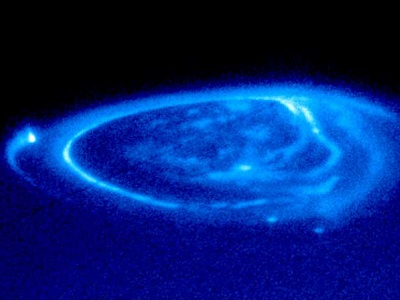 Jpiter tiene <a href="/jupiter/magnetosphere/jupiter_aurora.html&edu=elem&lang=sp&dev=1">auroras en sus polos</a>.  La aurora de Jpiter tiene una interesante interaccin con su luna <a href="/jupiter/moons/io.html&edu=elem&lang=sp&dev=1">Io</a>.  Los <a href="/earth/interior/volcanos_general.html&edu=elem&lang=sp&dev=1">volcanes</a> de Io liberan mucho sulfuro en el <a href="/jupiter/magnetosphere/Io_torus.html&edu=elem&lang=sp&dev=1">toroide</a> alrededor de Jpiter, que est embebido en el <a href="/jupiter/upper_atmosphere.html&edu=elem&lang=sp&dev=1">campo magntico</a> de Jpiter.  Las partculas de este toroide viajan a lo largo de las lneas del campo magntico hasta los polos de Jpiter, provocando <a href="/jupiter/magnetosphere/jupiter_aurora.html&edu=elem&lang=sp&dev=1">las luces aurorales</a>.<p><small><em>Imagen cortesa de J. Clarke (Universidad de Michigan) y NASA/ESA Hubble Space Telescope (Noviembre 26, 1998).</em></small></p>