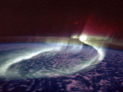 A sinuous glowing band of <a
  href="/earth/Magnetosphere/aurora.html&edu=high&dev=1/earth/Atmosphere/moons/triton_atmosphere.html">aurora</a> (the Aurora Australis
  or Southern Lights) loops around the <a
  href="/earth/polar/polar_south.html&edu=high&dev=1/earth/Atmosphere/moons/triton_atmosphere.html">southern polar</a>
region in the
  distance as viewed by astronauts onboard the space shuttle on <a
  href="http://www.nasa.gov/mission_pages/shuttle/shuttlemissions/archives/sts-39.html">STS-039</a>. 
  <a
  href="/earth/Magnetosphere/aurora/aurora_colors.html&edu=high&dev=1/earth/Atmosphere/moons/triton_atmosphere.html">Aurora are produced</a>
  when <a
  href="/physical_science/physics/atom_particle/particle_radiation.html&edu=high&dev=1/earth/Atmosphere/moons/triton_atmosphere.html">energetic particles</a>
 entering the Earth's
  atmosphere from space interact with <a
  href="/physical_science/physics/atom_particle/atom.html&edu=high&dev=1/earth/Atmosphere/moons/triton_atmosphere.html">atoms</a> and <a
  href="/earth/geology/molecule.html&edu=high&dev=1/earth/Atmosphere/moons/triton_atmosphere.html">molecules</a> in the atmosphere and
  release energy, emitted as light.<p><small><em>Courtesy of NASA, Astronaut Overmeyer and Dr. Hallinan</em></small></p>
